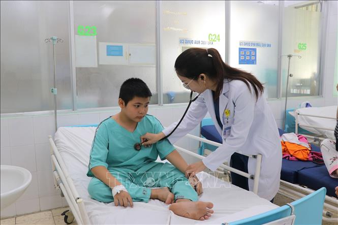 Bác sĩ Bệnh viện Nhi đồng Đồng Nai kiểm tra sức khỏe của bệnh nhi trước khi xuất viện. Ảnh: Lê Xuân-TTXVN