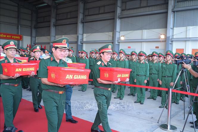 Thủ trưởng Bộ Tư lệnh Quân khu 9 đưa mẫu sinh phẩm hài cốt liệt sĩ lên máy bay. Ảnh: Hữu Tài/TTXVN phát