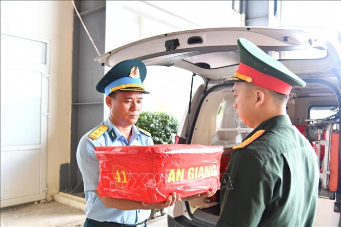 Trung tá Lương Trung Hải, Trợ lý Tác chiến Trung đoàn Không quân 917, tiếp nhận mẫu sinh phẩm từ Ban Chỉ đạo 515 tỉnh An Giang. Ảnh: Hữu Tài/TTXVN