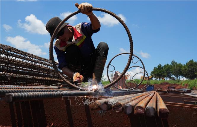 Một công nhân cho biết việc thi công cột khung cốt thép được tăng tốc cả khi trời nắng và trời mưa để đẩy nhanh tiến độ cho công trình. Ảnh: Nguyễn Dũng – TTXVN 

