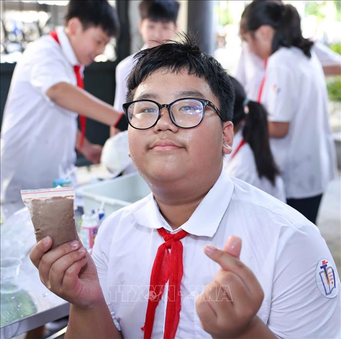 Học sinh hào hứng khoe sản phẩm kem do chính các em làm ra sau thực nghiệm khoa học với hoạt động “Làm kem không cần tủ đông”. Ảnh: Thanh Tùng – TTXVN