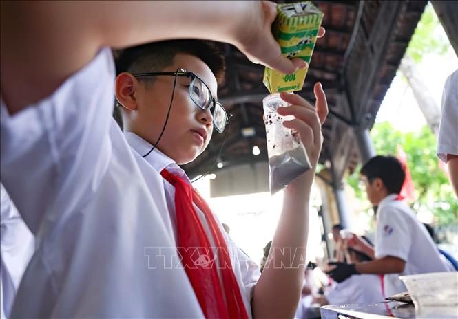 Học sinh thực nghiệm khoa học với hoạt động “Làm kem không cần tủ đông”, theo dõi sự thay đổi nhiệt độ theo thời gian và thử thách thiết kế giải pháp “Giữ kem lâu tan”. Ảnh: Thanh Tùng - TTXVN