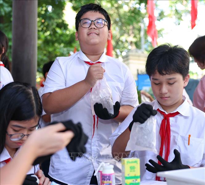 Học sinh thực nghiệm khoa học với hoạt động “Làm kem không cần tủ đông”, theo dõi sự thay đổi nhiệt độ theo thời gian và thử thách thiết kế giải pháp “Giữ kem lâu tan”. Ảnh: Thanh Tùng - TTXVN