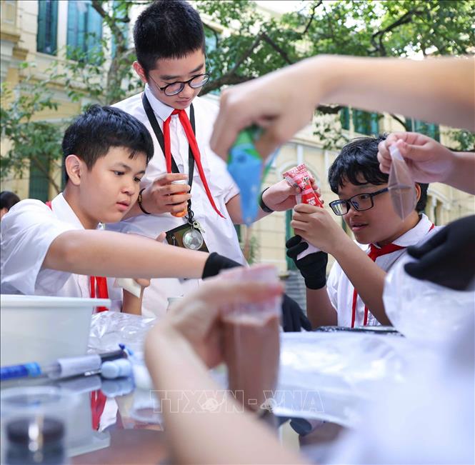 Học sinh thực nghiệm khoa học với hoạt động “Làm kem không cần tủ đông”, theo dõi sự thay đổi nhiệt độ theo thời gian và thử thách thiết kế giải pháp “Giữ kem lâu tan”. Ảnh: Thanh Tùng - TTXVN