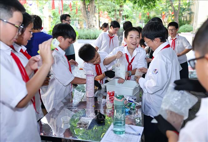 Học sinh thực nghiệm khoa học với hoạt động “Làm kem không cần tủ đông”, theo dõi sự thay đổi nhiệt độ theo thời gian và thử thách thiết kế giải pháp “Giữ kem lâu tan”. Ảnh: Thanh Tùng - TTXVN