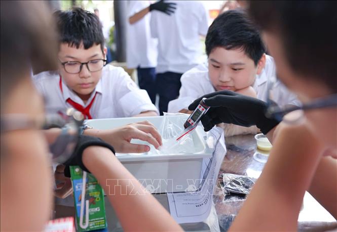 Trạm thứ ba tập trung vào thực nghiệm khoa học với hoạt động “Làm kem không cần tủ đông”, theo dõi sự thay đổi nhiệt độ theo thời gian và thử thách thiết kế giải pháp “Giữ kem lâu tan”. Qua đó, các em được trực tiếp lựa chọn vật liệu, tiến hành thử nghiệm, ghi nhận số liệu, đánh giá kết quả và điều chỉnh phương án. Ảnh: Thanh Tùng - TTXVN