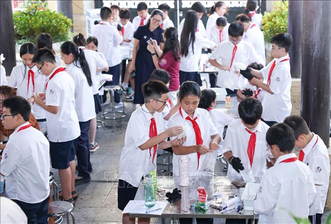 Học sinh thực nghiệm khoa học với hoạt động “Làm kem không cần tủ đông”, theo dõi sự thay đổi nhiệt độ theo thời gian và thử thách thiết kế giải pháp “Giữ kem lâu tan”. Ảnh: Thanh Tùng - TTXVN