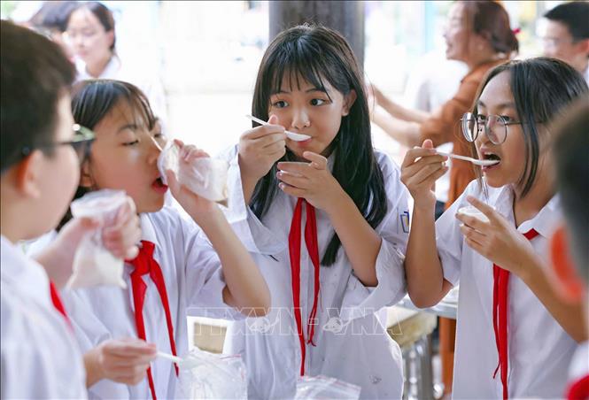 Học sinh hào hứng thưởng thức sản phẩm kem do chính các em làm ra sau thực nghiệm khoa học với hoạt động “Làm kem không cần tủ đông”. Ảnh: Thanh Tùng – TTXVN