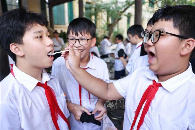 Học sinh hào hứng thưởng thức sản phẩm kem do chính các em làm ra sau thực nghiệm khoa học với hoạt động “Làm kem không cần tủ đông”. Ảnh: Thanh Tùng – TTXVN