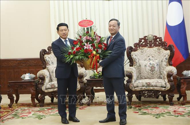 Đại sứ Việt Nam tại Lào Nguyễn Minh Tâm chuyển lẵng hoa chúc mừng của đồng chí Lê Minh Hưng, Ủy viên Bộ Chính trị, Thủ tướng Chính phủ Việt Nam chúc mừng đồng chí Saleumxay Kommasitt, Ủy viên Bộ Chính trị, Thủ tướng Chính phủ Lào. Ảnh: Xuân Tú - PV TTXVN tại Lào