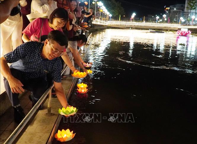 Người dân thả hoa đăng (được làm từ những vật liệu tự nhiên để bảo vệ môi trường) trên dòng sông Kiên. Ảnh: Văn Sĩ - TTXVN                               
