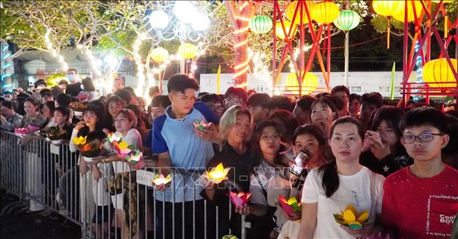 Người dân chuẩn bị hoa đăng thả xuống dòng sông Kiên. Ảnh: Văn Sĩ - TTXVN