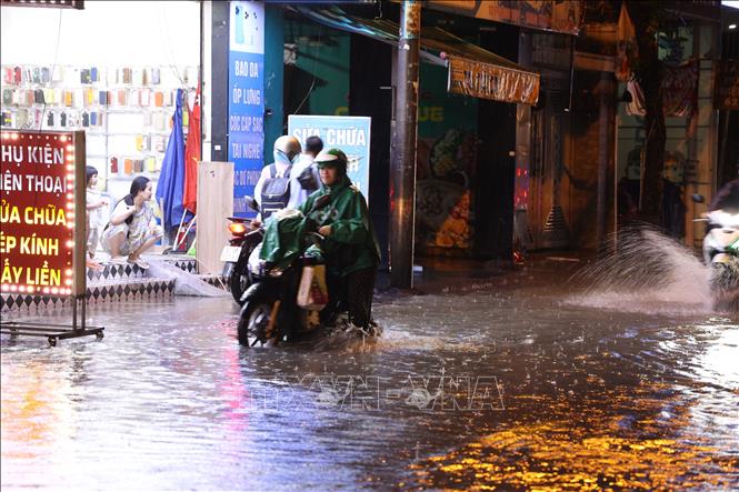 Xe chết máy phải dắt bộ qua đoạn ngập nặng trên đường Phan Huy Ích (phường Tân Sơn) trong cơn mưa tối 7/10. Ảnh: Hồng Đạt - TTXVN 