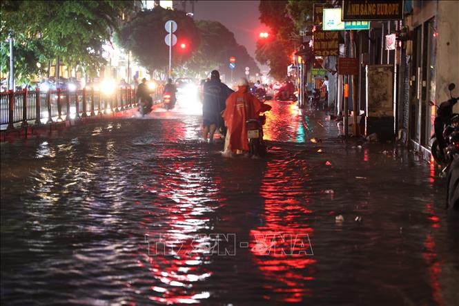 Xe chết máy, người dân phải dắt bộ qua đoạn ngập trên đường Phan Văn Trị, phường Hạnh Thông, tối 7/10. Ảnh: Hồng Đạt - TTXVN 