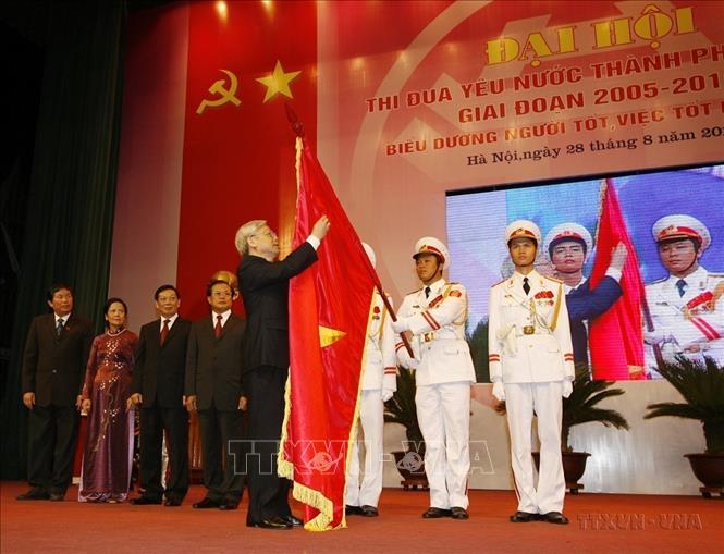 Chủ tịch Quốc hội Nguyễn Phú Trọng gắn Huân chương Sao Vàng lên lá cờ truyền thống của Thành phố Hà Nội tại Đại hội thi đua yêu nước thành phố giai đoạn 2005 - 2010. Ảnh : Trí Dũng - TTXVN