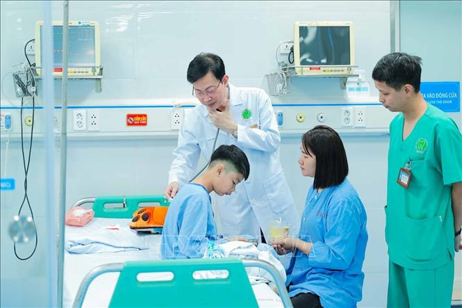 PGS.TS, Thầy thuốc Nhân dân Nguyễn Quang Bình Nguyễn Quang Bình thăm khám cho bệnh nhi tại Bệnh viện Răng Hàm Mặt Trung ương Hà Nội. Với ông, sự tận tâm trong chăm sóc người bệnh là cách thể hiện đạo đức nghề y trong công việc hằng ngày. Ảnh: Phạm Tuấn Anh - TTXVN