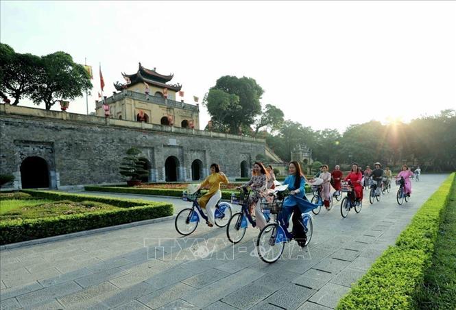 Với cộng đồng quốc tế, Thủ đô Hà Nội là một thành phố luôn phát triển năng động nhưng vẫn giữ những nét truyền thống. Trong ảnh: Phụ nữ Thủ đô trong trang phục áo dài đạp xe qua các điểm di sản của Hà Nội trong “Áo dài kết nối du lịch và di sản Hà Nội lần thứ nhất - năm 2023”. Ảnh: Nhật Anh - TTXVN