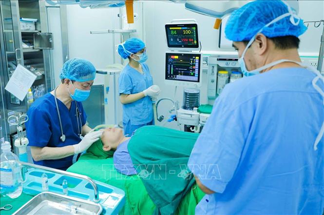 PGS.TS, Thầy thuốc Nhân dân Nguyễn Quang Bình Nguyễn Quang Bình cùng ê kíp thực hiện công tác gây mê cho người bệnh tại phòng mổ, Bệnh viện Răng Hàm Mặt Trung ương Hà Nội. Công việc trực tiếp bên bàn mổ gắn liền với hành trình cống hiến của ông trong chuyên ngành gây mê hồi sức. Ảnh: Phạm Tuấn Anh - TTXVN
