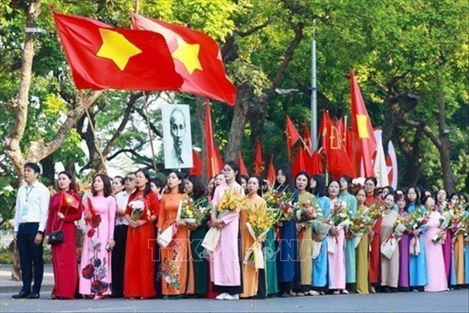 Quần chúng nhân dân Thủ đô chào cờ, hát quốc ca, tái hiện buổi lễ chào cờ đầu tiên tại Hà Nội vào ngày 10/10/1954 trong Lễ kỷ niệm 70 năm giải phóng Thủ đô, tại Hà Nội, ngày 10/10/2024. Ảnh: Dương Giang - TTXVN