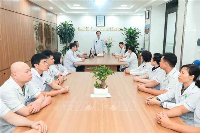 PGS.TS Nguyễn Quang Bình chủ trì buổi trao đổi công việc với đội ngũ nhân viên Khoa Gây mê hồi sức và Chống đau. Trên cương vị trưởng khoa, ông cùng đồng nghiệp thực hiện nhiệm vụ chuyên môn, gắn công tác điều trị với đào tạo và phát triển đội ngũ. Ảnh: Phạm Tuấn Anh - TTXVN