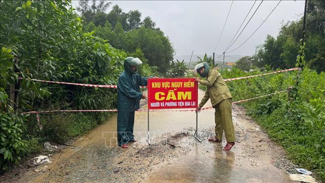 Lực lượng chức năng thành phố Đà Nẵng cắm biển cảnh báo tại những vùng bị ngập lụt do mưa lớn. Ảnh: TTXVN phát