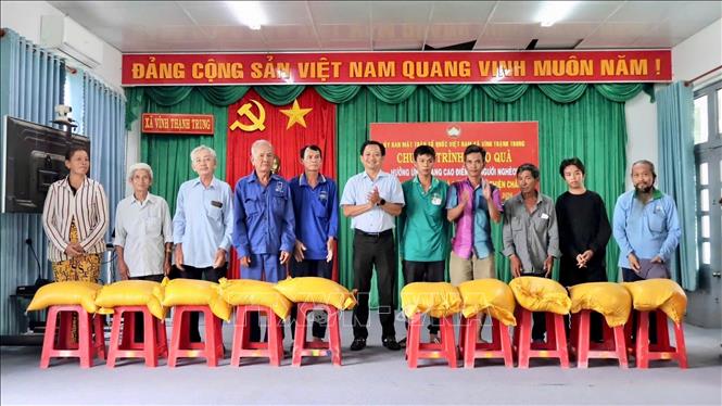 Lãnh đạo xã Vĩnh Thạnh Trung trao gạo hỗ trợ các hộ nghèo, hộ cận nghèo. Ảnh: Thanh Sang – TTXVN
