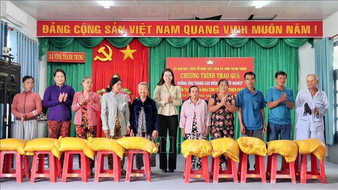 Đại diện Ủy ban MTTQ Việt Nam xã Vĩnh Thạnh Trung trao gạo cho các hộ khó khăn trên địa bàn. Ảnh: Thanh Sang – TTXVN