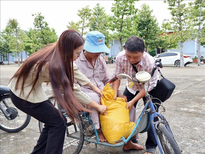 Hoạt động trao gạo góp phần giúp các hộ khó khăn giảm bớt chi phí sinh hoạt. Ảnh: Thanh Sang – TTXVN
