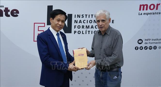 Phó Giám đốc Học viện Chính trị quốc gia Hồ Chí Minh Hoàng Phúc Lâm tặng cuốn sách “Khát vọng Việt Nam hùng cường trong kỷ nguyên mới’’ cho lãnh đạo Viện đào tạo cán bộ đảng Morena cầm quyền. Ảnh: Phi Hùng - PV TTXVN tại Mexico