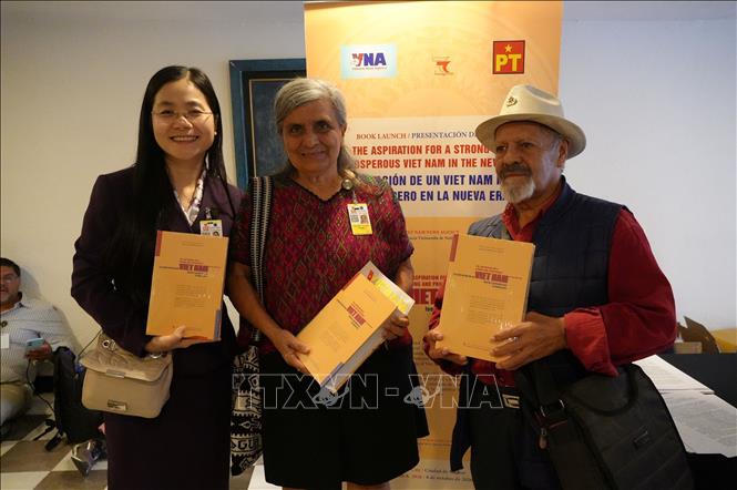 Các đại biểu cầm trên tay cuốn sách “Khát vọng Việt Nam hùng cường trong kỷ nguyên mới’’ tập hợp các bài viết, phát biểu tiêu biểu của Tổng Bí thư, Chủ tịch nước Tô Lâm. Ảnh: Phi Hùng - PV TTXVN tại Mexico