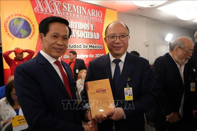 Phó Giám đốc Học viện Chính trị quốc gia Hồ Chí Minh Hoàng Phúc Lâm tặng cuốn sách “Khát vọng Việt Nam hùng cường trong kỷ nguyên mới’’ cho Trưởng đoàn Trung Quốc. Ảnh: Phi Hùng - PV TTXVN tại Mexico