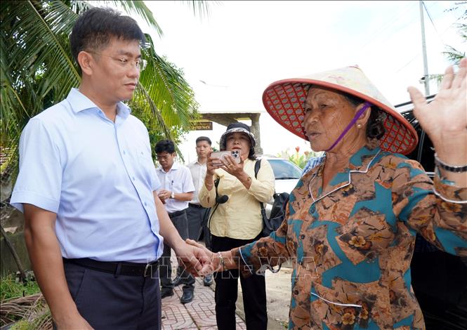 Phó Chủ tịch Ủy ban nhân dân tỉnh Quảng Ngãi Đỗ Tâm Hiển (bên trái ảnh) động viên người dân vùng bị ngập nặng. Ảnh: Lê Phước Ngọc - TTXVN 