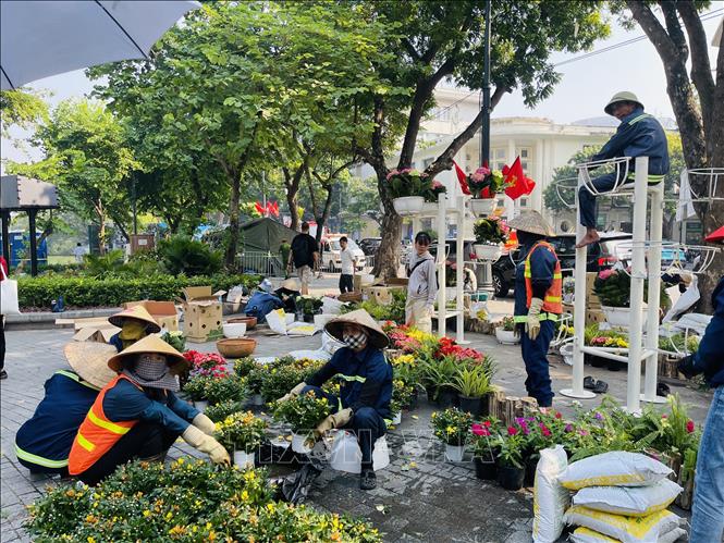 Các công nhân khẩn trương chuẩn bị hoa trang trí cụm tiểu cảnh chào mừng kỷ niệm 72 năm Ngày Giải phóng Thủ đô bên hồ Hoàn Kiếm. Ảnh: Tuyết Mai - TTXVN