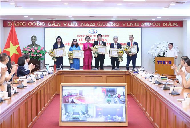Đồng chí Vũ Việt Trang, Ủy viên Ban Thường vụ Đảng ủy các cơ quan Đảng Trung ương, Bí thư Đảng ủy, Tổng Giám đốc Thông tấn xã Việt Nam, Phó Trưởng ban Tuyên giáo Trung ương trao Huy hiệu 40 năm, 35 năm và 30 năm tuổi Đảng cho các đảng viên. Ảnh: An Đăng - TTXVN