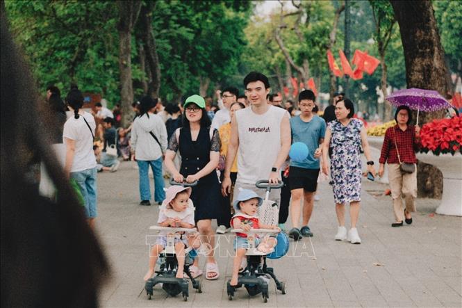 Các gia đình đưa con nhỏ dạo chơi trên không gian đi bộ hồ Hoàn Kiếm trong ngày kỷ niệm 72 năm Giải phóng Thủ đô. Ảnh: Phạm Tuấn Anh - TTXVN