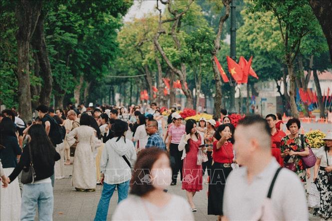 Đông đảo người dân và du khách dạo chơi trên tuyến phố rợp bóng cây và cờ Tổ quốc quanh hồ Hoàn Kiếm trong ngày 10/10/2026. Ảnh: Phạm Tuấn Anh - TTXVN