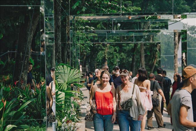 Du khách quốc tế tham quan, dạo bước giữa hệ thống khung gương nghệ thuật tại không gian “Dải lụa ký ức” bên hồ Hoàn Kiếm. Ảnh: Phạm Tuấn Anh - TTXVN