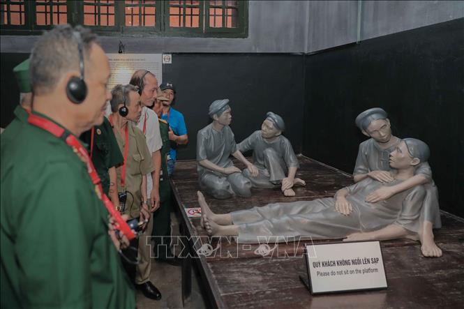 Du khách trải nghiệm thiết bị thuyết minh tự động với 8 ngôn ngữ, tìm hiểu nội dung trưng bày theo cách chủ động tại Di tích Nhà tù Hỏa Lò. Ảnh: Phan Phương – TTXVN