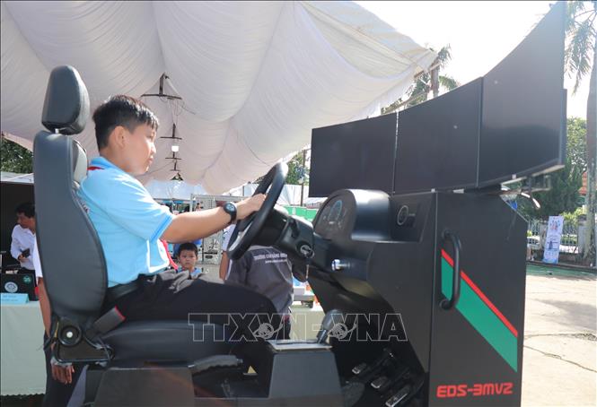 Học sinh trải nghiệm thiết bị mô phỏng lái xe tại khu vực trưng bày công nghệ trong khuôn khổ các hoạt động hưởng ứng Ngày Chuyển đổi số quốc gia năm 2026 tại phường Bình Phước. Ảnh: Đậu Tất Thành - TTXVN