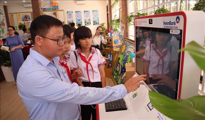 Cán bộ hướng dẫn học sinh trải nghiệm Kiosk dịch vụ công tại không gian đổi mới sáng tạo phường Bình Phước, giúp các em tiếp cận phương thức thực hiện thủ tục hành chính trên môi trường số. Ảnh: Đậu Tất Thành - TTXVN
