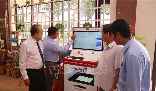 Các đại biểu tìm hiểu hoạt động của Kiosk thông minh - Trạm Dịch vụ công số tại phường Bình Phước. Thiết bị được kỳ vọng tạo thêm phương thức tiếp cận dịch vụ công trực tuyến, giúp người dân từng bước làm quen với việc thực hiện thủ tục hành chính bằng công nghệ. Ảnh: Đậu Tất Thành - TTXVN