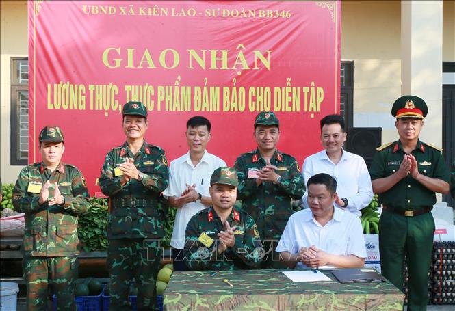 Đại diện lãnh đạo, chỉ huy Sư đoàn 346 và xã Kiên Lao, tỉnh Bắc Ninh ký kết giao nhận lương thực, thực phẩm phục vụ bộ đội hành quân, dã ngoại. Ảnh: Trọng Đức - TTXVN