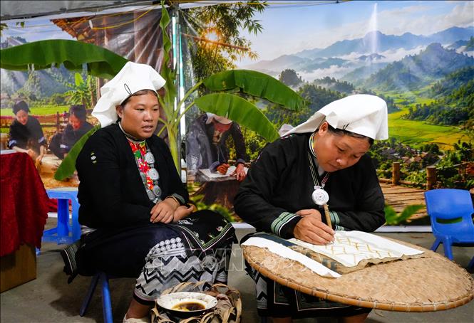 Chị Chu Thị Huế (xóm Nà Chắn, xã Tam Kim) đang in hoa văn bằng sáp ong của người Dao Tiền. Ảnh: Chu Hiệu-TTXVN.