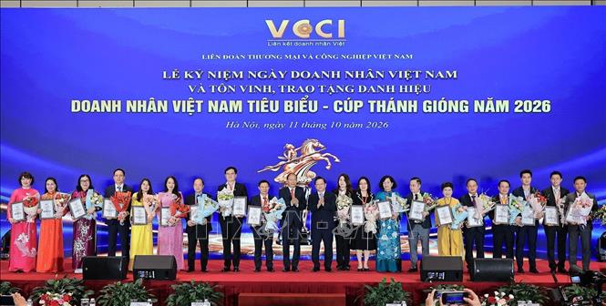 Ông Nguyễn Đức Hiển, Phó Trưởng Ban chính sách, chiến lực Trung ương và ông Hoàng Quang Phòng, Phó Chủ tịch Liên đoàn Thương mại và Công nghiệp Việt Nam (VCCI) trao hoa và bằng khen cho những Doanh nhân xuất sắc. Ảnh: Lê Đông - TTXVN