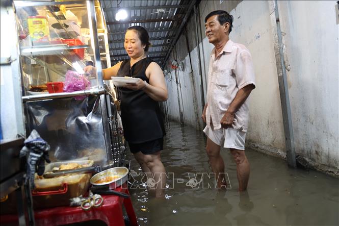 Chị Nguyễn Thị Cẩm Ly bán cơm cho ông Nguyễn Phước Trung là khách quen ở gần nhà. Ảnh: Hồng Đạt - TTXVN