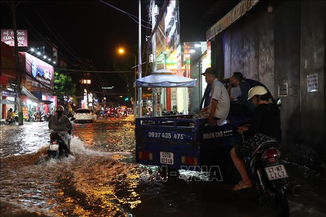 Nhiều người dân lao động TP. Hồ Chí Minh cũng phải ngừng việc mưu sinh vì triều cường. Ảnh: Hồng Đạt - TTXVN