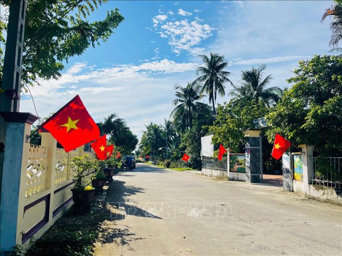 Những lá cờ được treo dọc các tuyến đường không chỉ làm đẹp cảnh quan mà còn gắn với việc vận động người dân giữ gìn vệ sinh, bảo đảm đường làng, ngõ xóm sạch sẽ. Ảnh Khiếu Tư - TTXVN