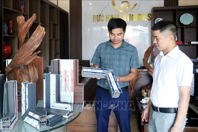 Anh Trần Thiện Nam, Giám đốc điều hành Công ty TNHH Sản xuất và Phát triển Xây dựng Đức Nam, xã Bình Giang, tỉnh Ninh Bình, giới thiệu sản phẩm của doanh nghiệp. Ảnh: Nguyễn Lành - TTXVN