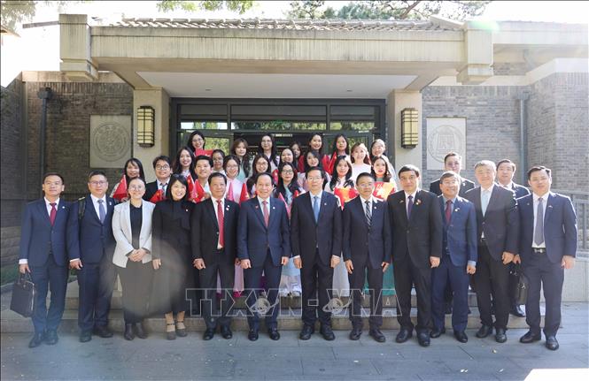 Phó Thủ tướng Chính phủ Lê Tiến Châu và Giáo sư Khưu Dũng, Bí thư Đảng ủy Trường Đại học Thanh Hoa, chụp ảnh chung cùng các thầy cô giáo và lưu học sinh Việt Nam đang học tại trường Đại học Thanh Hoa. Ảnh: Công Tuyên - PV TTXVN tại Trung Quốc