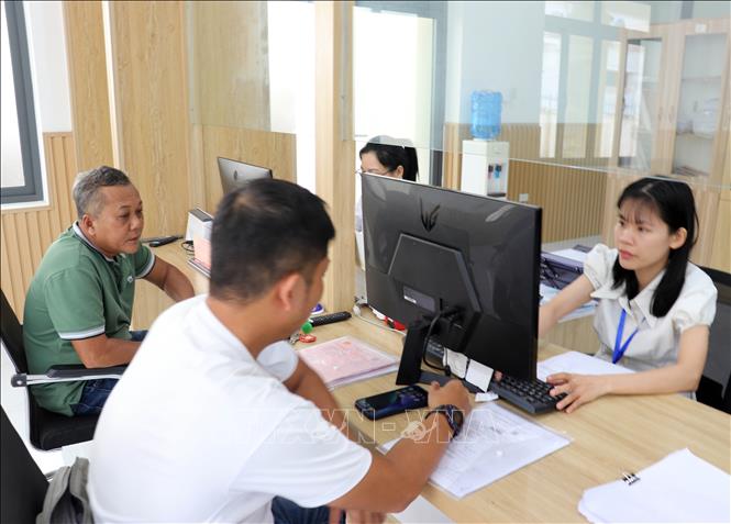 Cán bộ Trung tâm Phục vụ hành chính công phường Cam Ranh xử lý hồ sơ về đất đai cho người dân. Ảnh: Công Thử - TTXVN